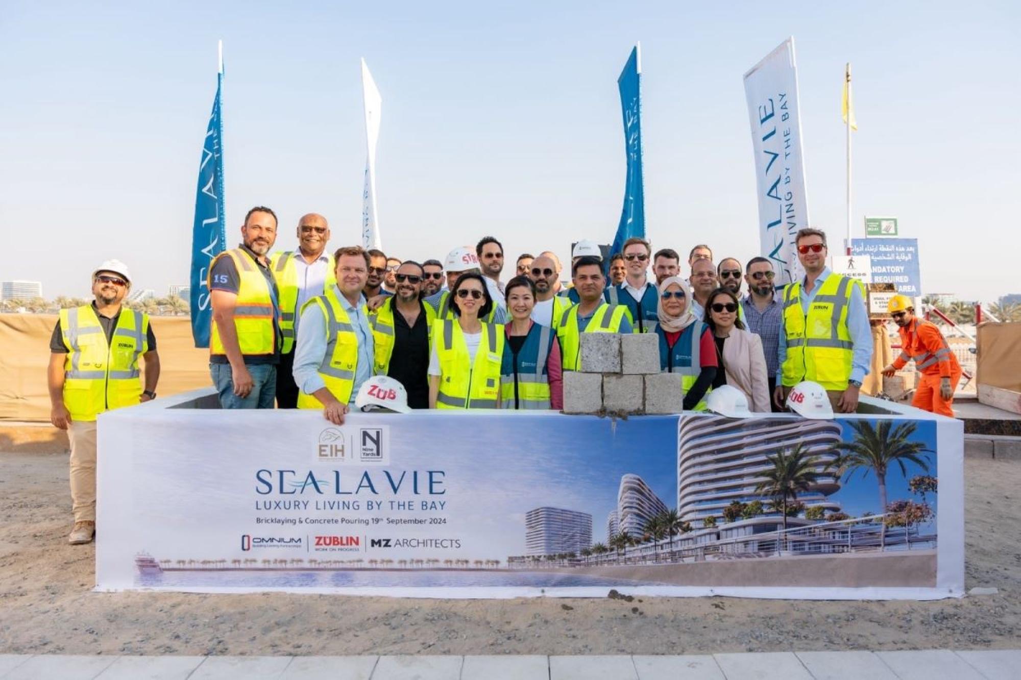 Omnium team members surrounded with banner to announce the construction of Sea La Vie.